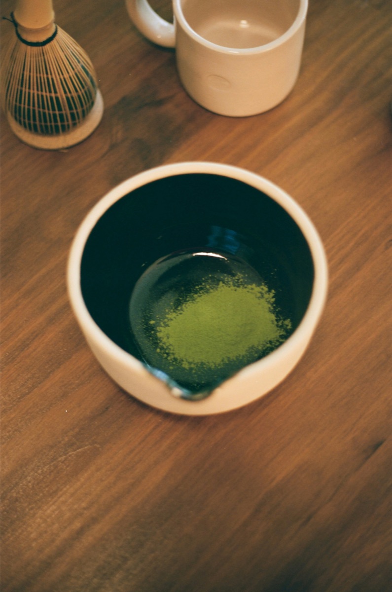 Matcha powder in a ceramic bowl, ready to be whisked.